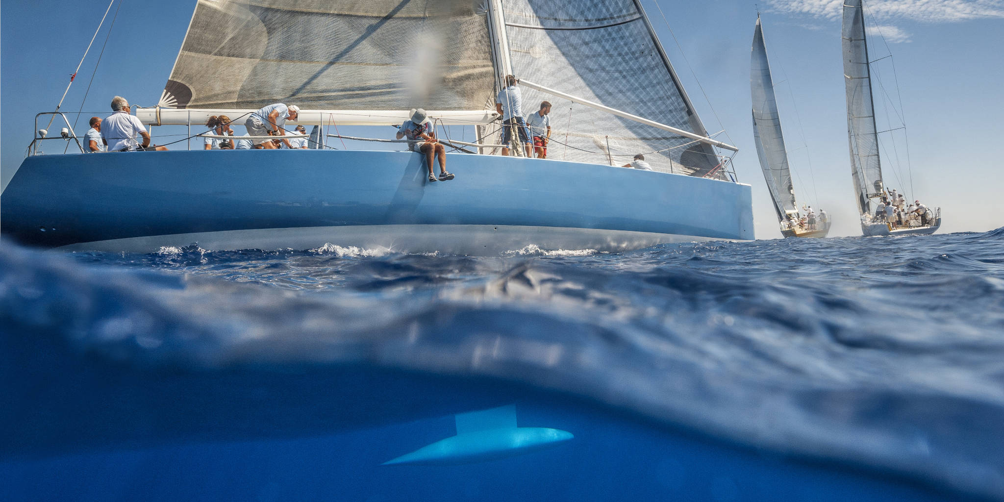 Blue sailing boat on the sea with keel under water