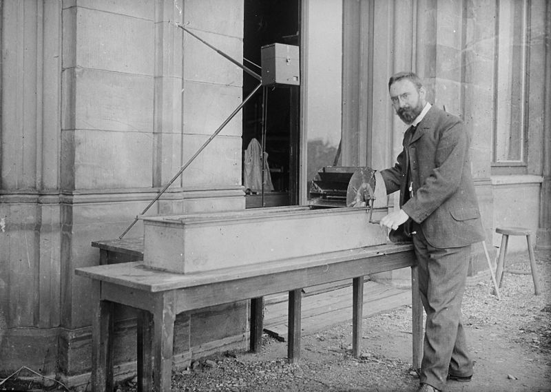 Ludwig Prandtl (1875-1953) in front of his research water channel in Hannover in 1904. The water was propelled with a hand-operated paddlewheel along the 1.5-meter long duct. A series of blades and meshes streamlined the flow adequately.